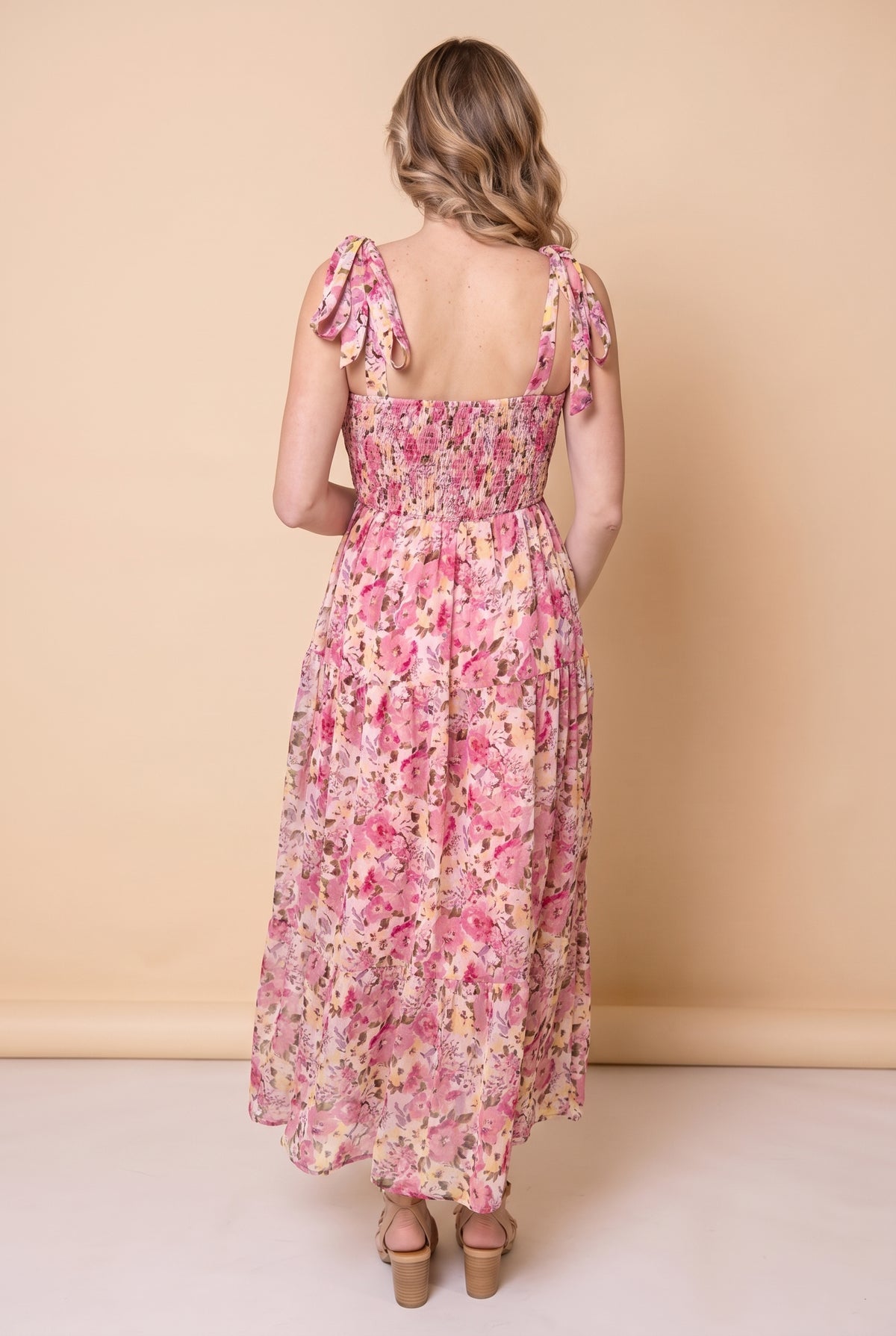 Back view of the pink floral smocked maxi dress showing the smocked back and tie strap bows.