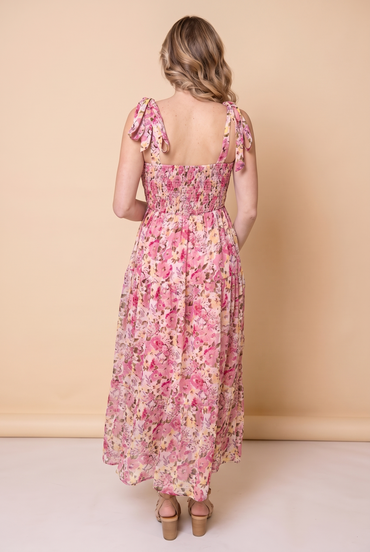 Back view of the pink floral smocked maxi dress showing the smocked back and tie strap bows.