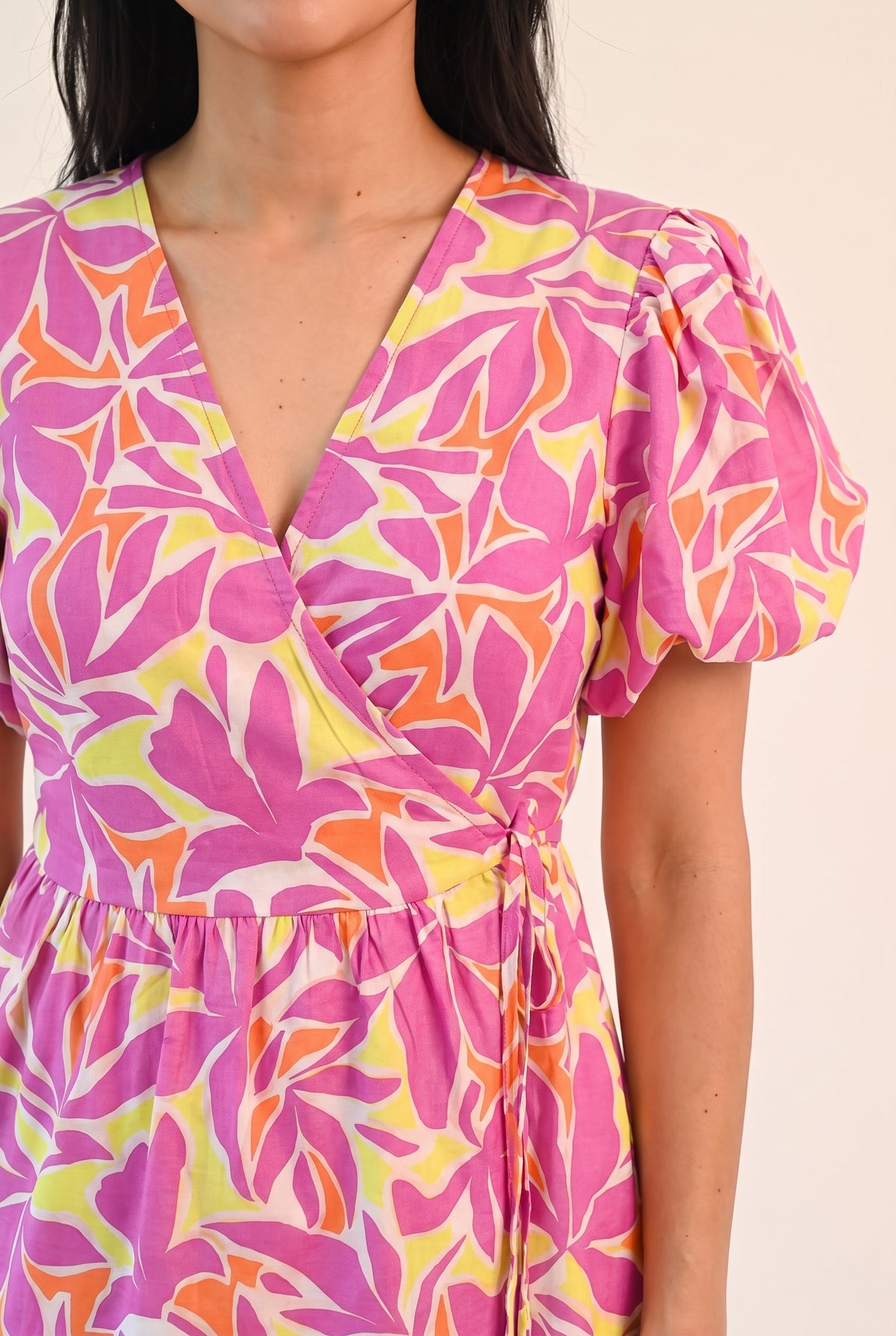 Close view of the Somewhere Sunny wrap V-neck, puff sleeve and leaf print