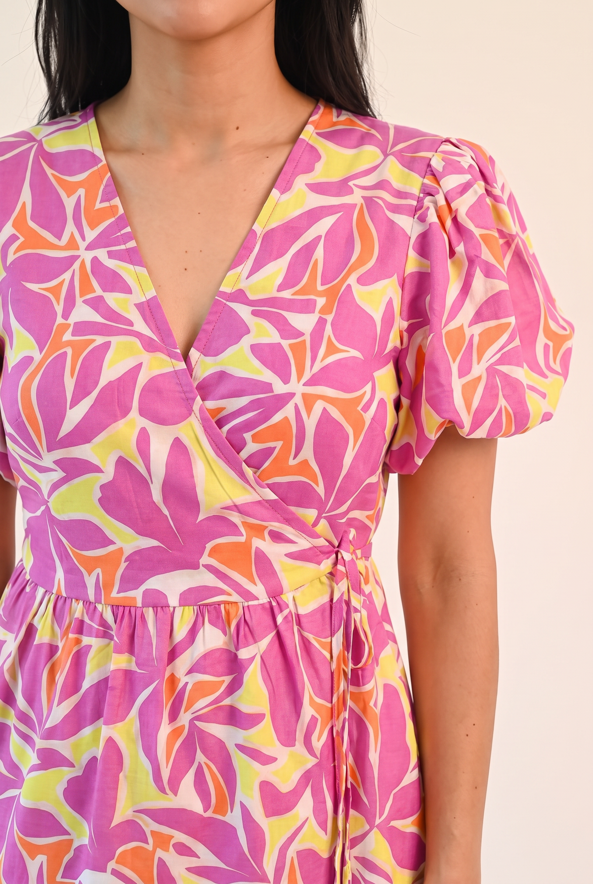 Close view of the Somewhere Sunny wrap V-neck, puff sleeve and leaf print