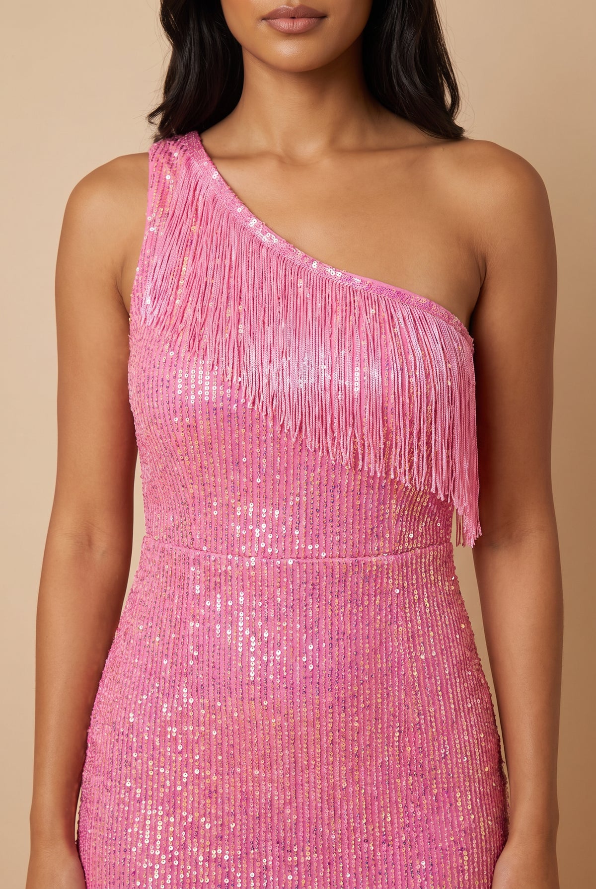 Close view of the iridescent pink sequins and the fringe along the one-shoulder neckline