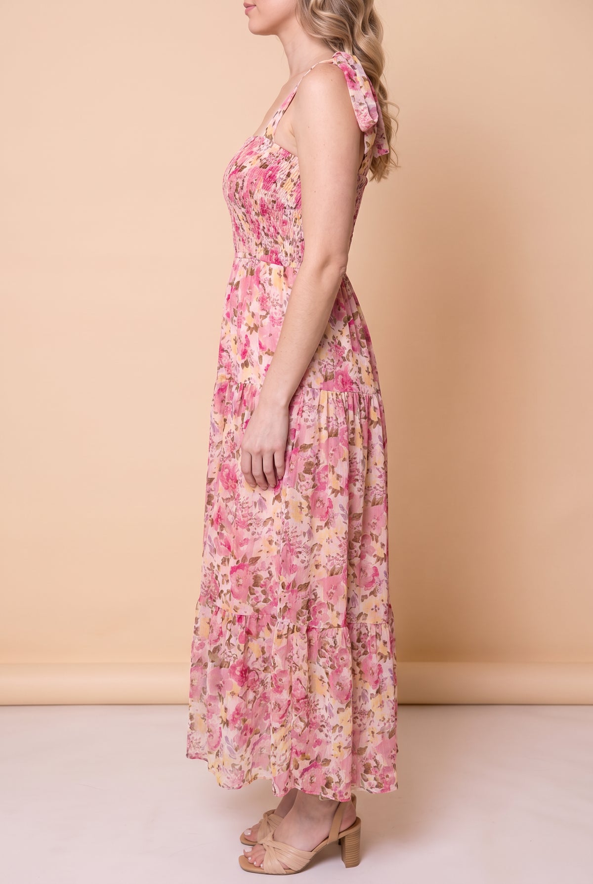 Side view of the pink floral smocked maxi dress showing the flowing tiered skirt and ankle length.