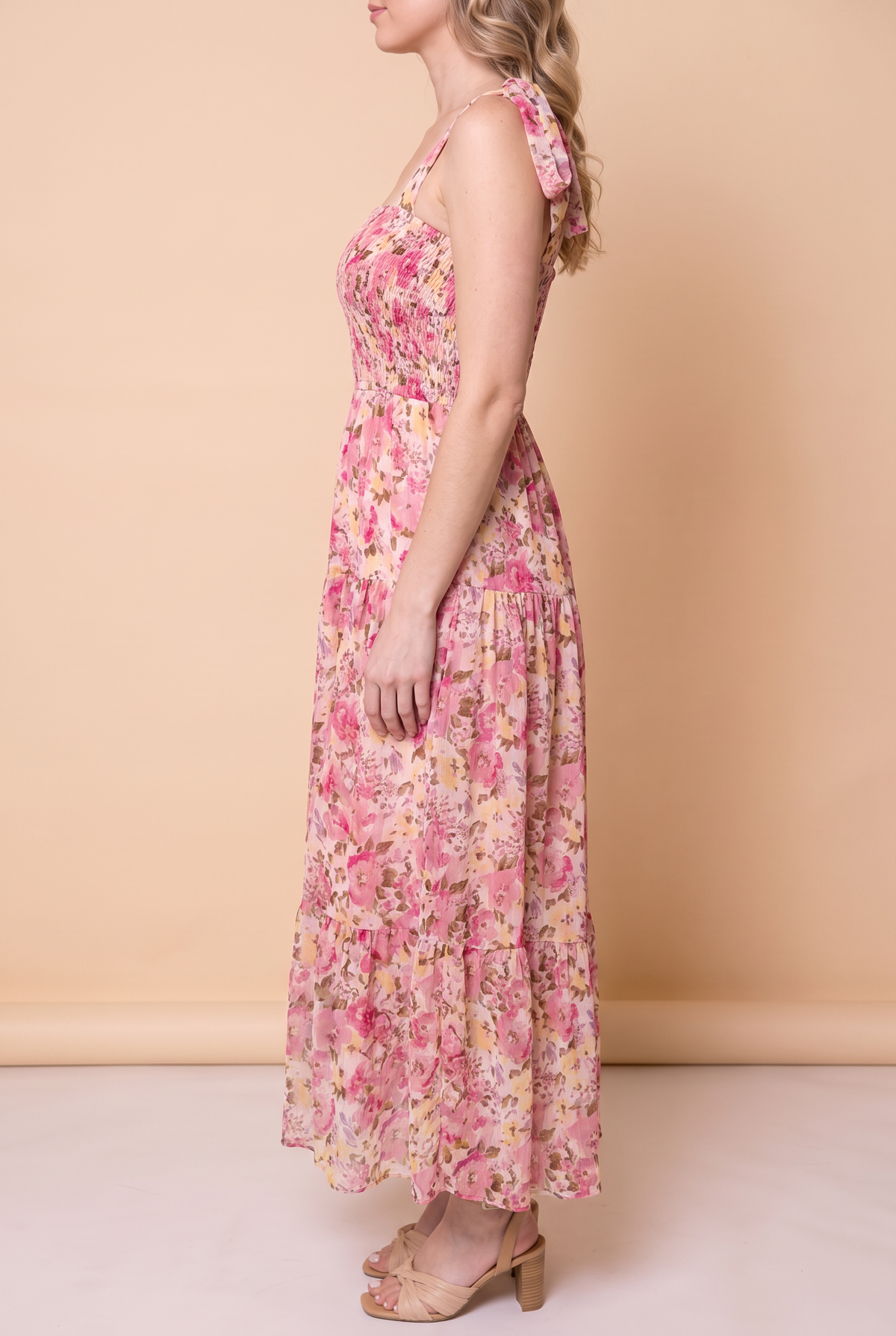 Side view of the pink floral smocked maxi dress showing the flowing tiered skirt and ankle length.