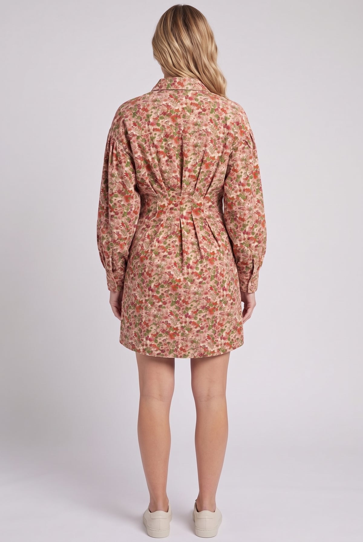 Back view of the floral corduroy shirt dress showing the shirt collar, back waist pleats, balloon sleeves and mid-thigh hem.