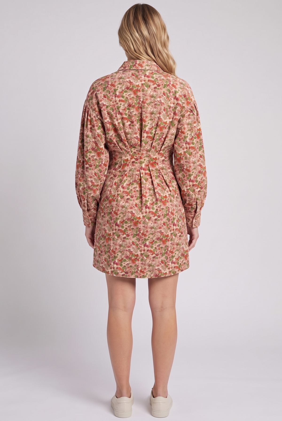 Back view of the floral corduroy shirt dress showing the shirt collar, back waist pleats, balloon sleeves and mid-thigh hem.