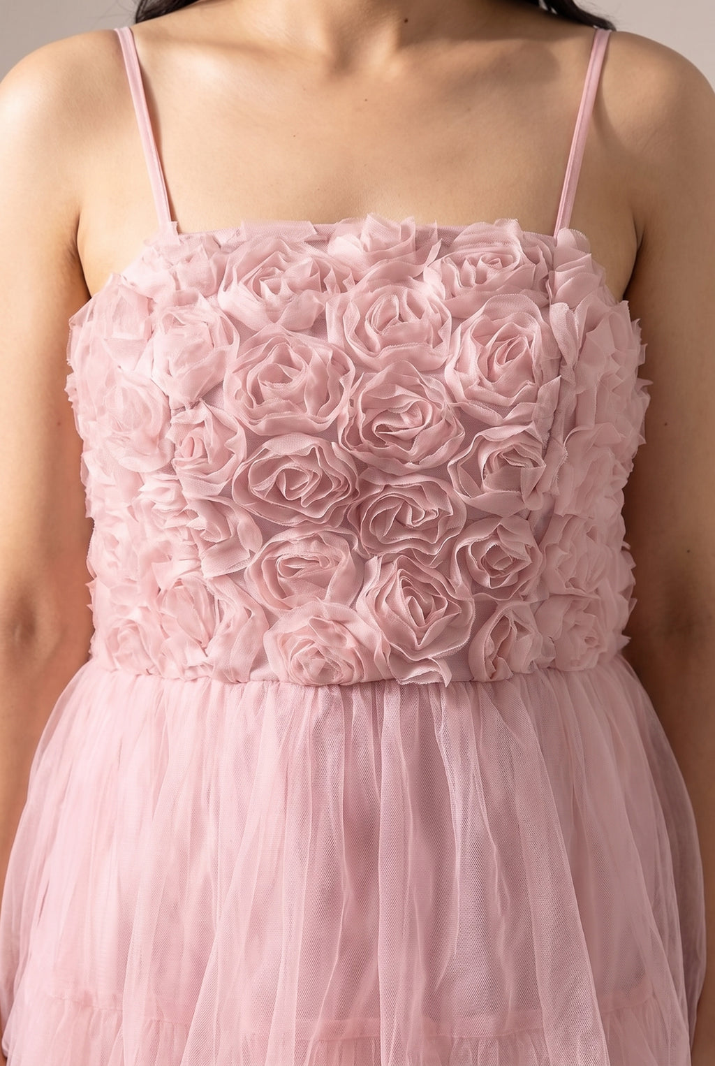 Close detail of the 3D fabric rosettes on the bodice and the gathered blush tulle skirt.