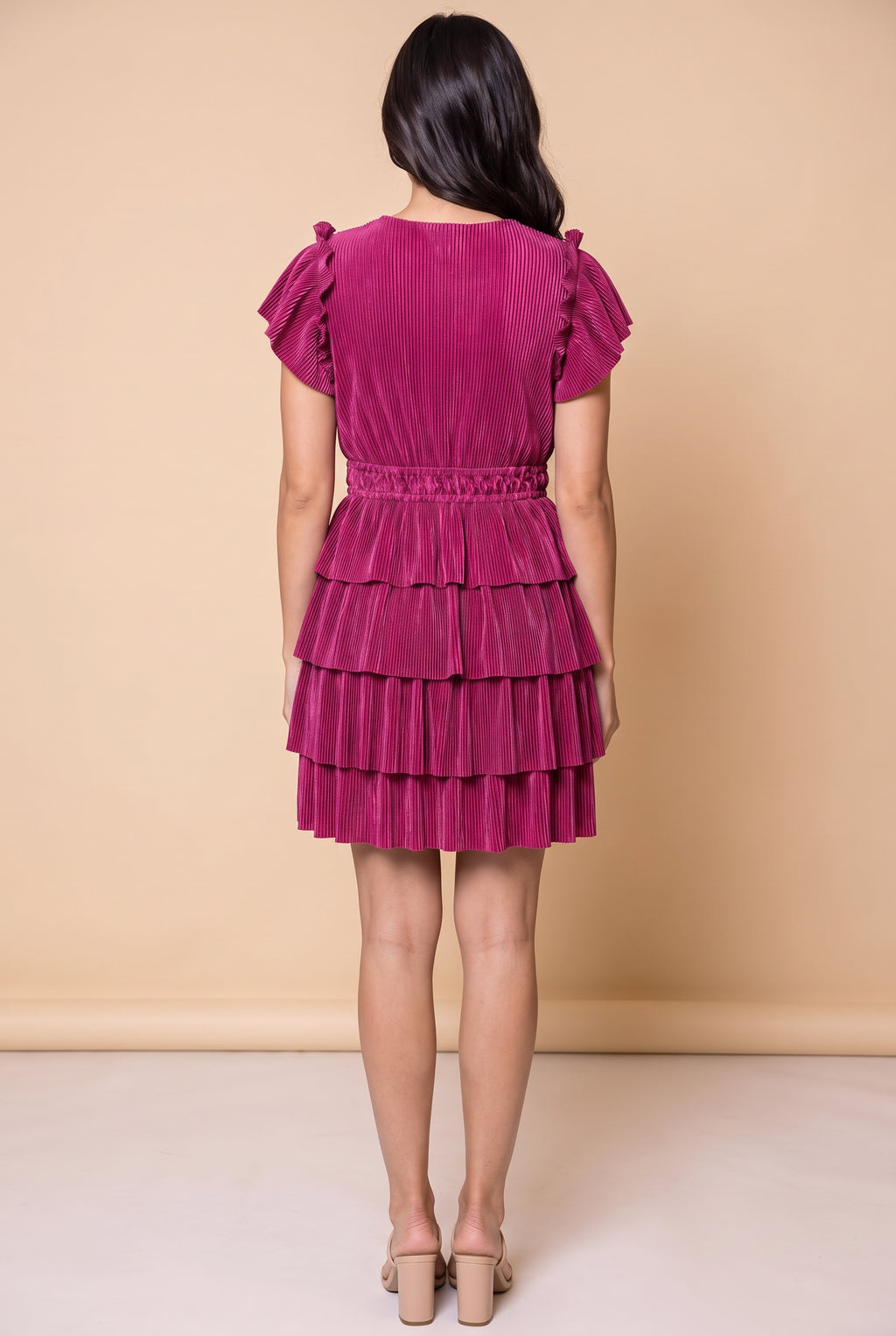Back view of the magenta tiered plisse dress showing the smocked waist and ruffle tiers.