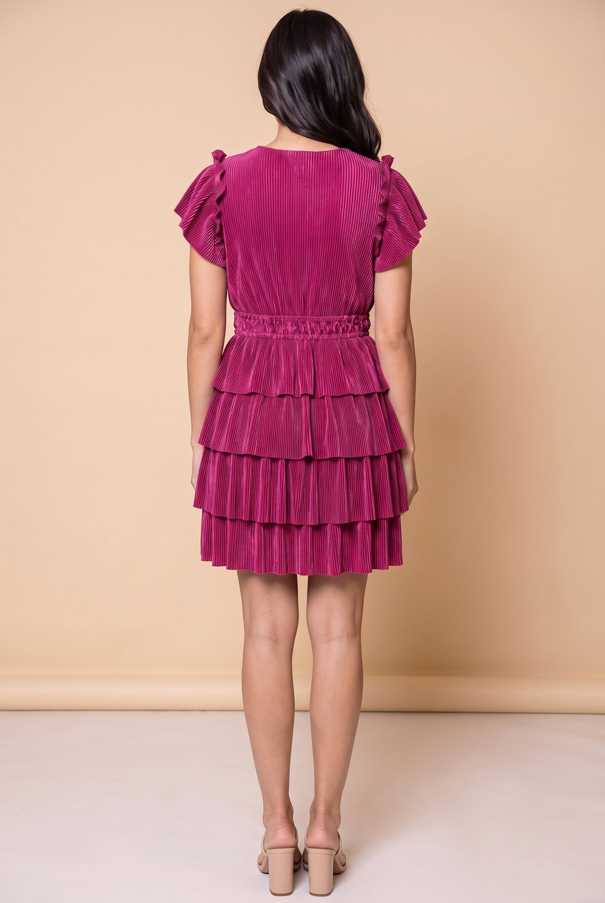 Back view of the magenta tiered plisse dress showing the smocked waist and ruffle tiers.