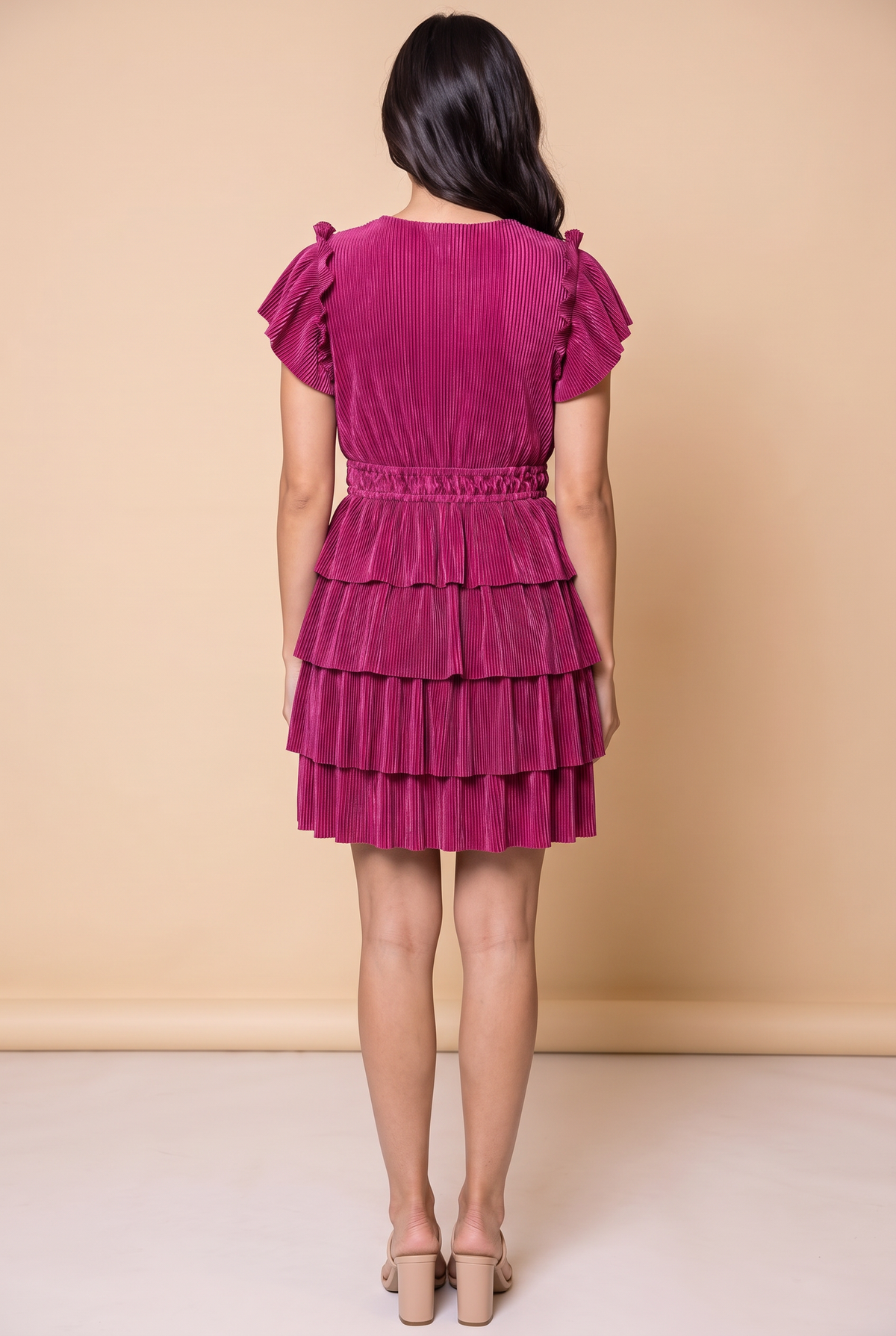 Back view of the magenta tiered plisse dress showing the smocked waist and ruffle tiers.