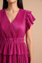 Close-up of the fine plisse pleats, surplice V neckline, flutter sleeve and smocked elastic waistband.