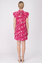 Back view of the pink pleated print shift dress showing the keyhole and tie at the back neck, flutter sleeves and plain hem above the knee.