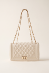 Jacqueline beige quilted vegan leather shoulder bag with gold chain strap and twist lock, on a plain studio background