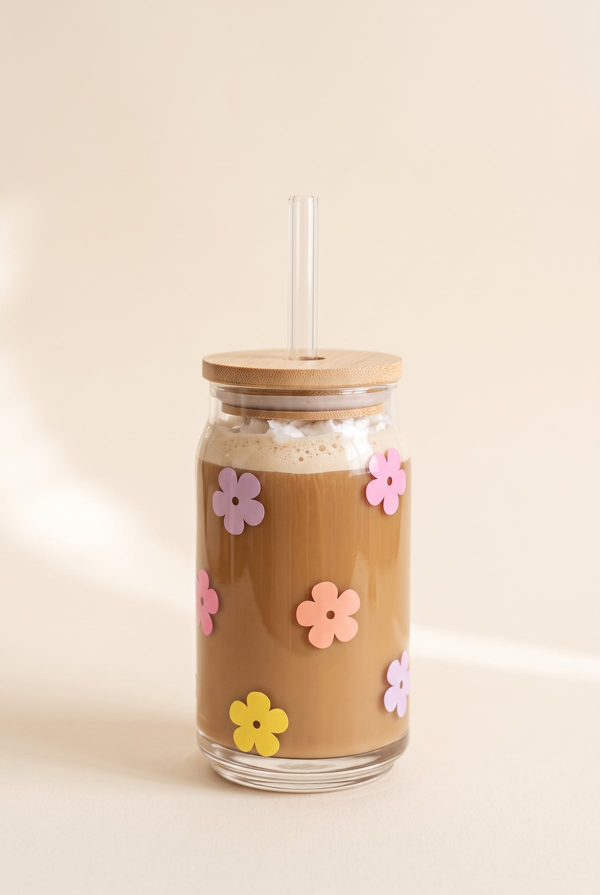 Josie Daisy Glass Cup, 16 oz clear can glass with iced latte, bamboo lid, glass straw and small lilac, pink, peach and yellow flowers
