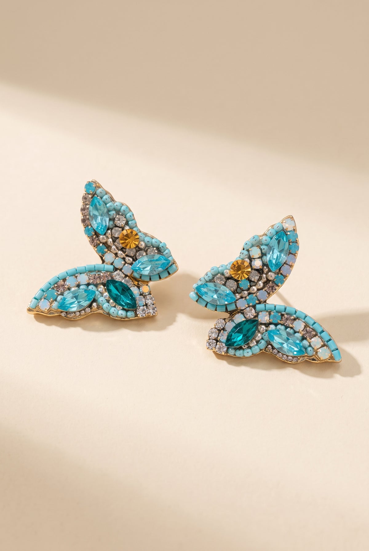 June Butterfly Earrings in Turquoise: half-butterfly studs with turquoise beads, aqua and teal marquise stones and an amber accent stone