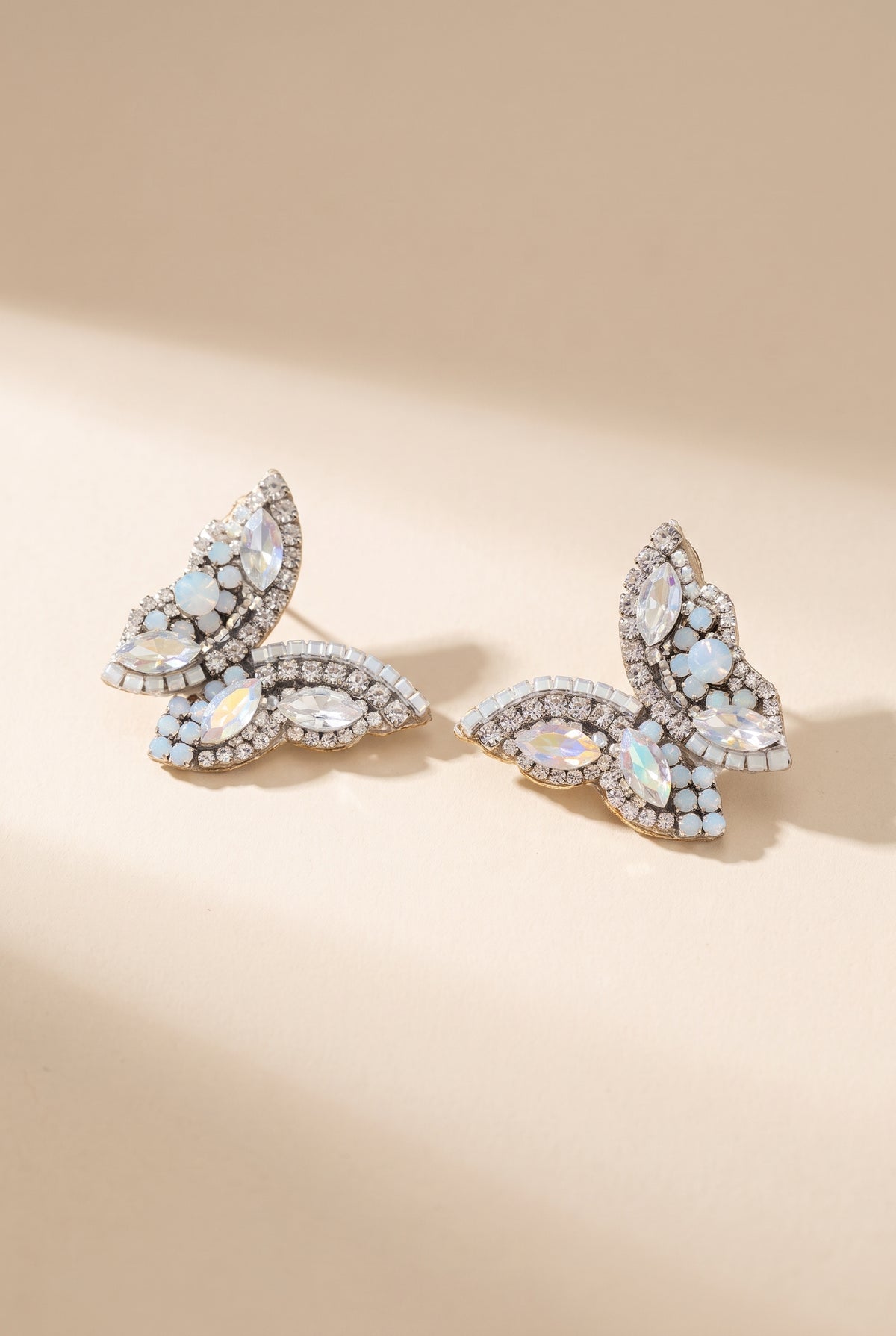 June Butterfly Earrings in White: half-butterfly studs with clear and opal marquise stones and clear rhinestone borders