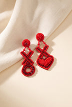 Lily Hugs and Kisses Beaded Earrings: an intentionally mismatched pair, one red beaded X and O, one X and heart, edged with dark red rhinestones