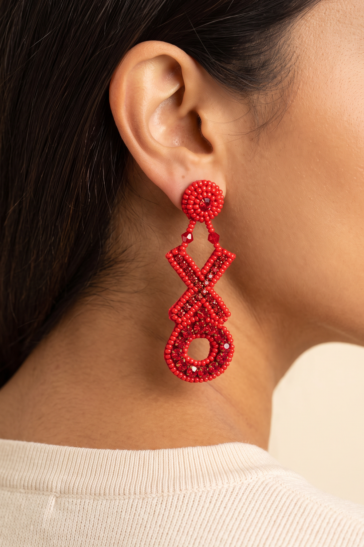 Lily Hugs and Kisses X and O earring worn on the ear at true size, about 3 in long, ending just below the jawline