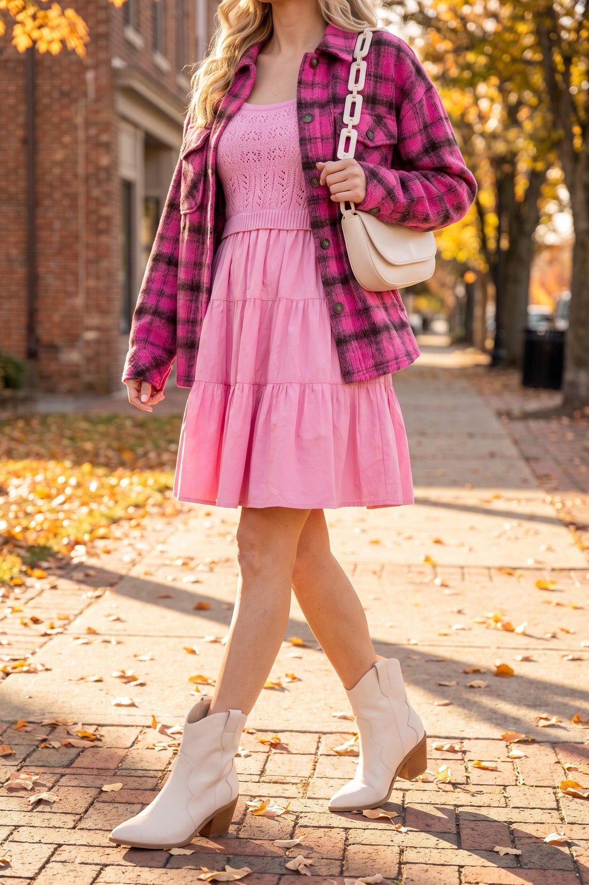 Light pink crochet dress styled for fall with a pink plaid shacket, a cream chain shoulder bag and cream western ankle boots