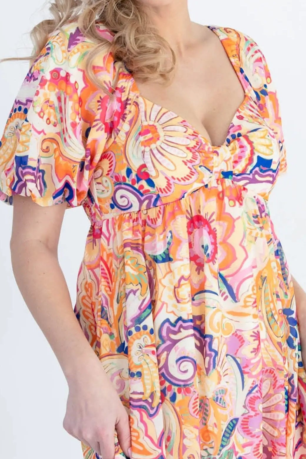 Close-up of the orange, pink, purple and blue paisley floral print, sweetheart neckline and puff sleeve
