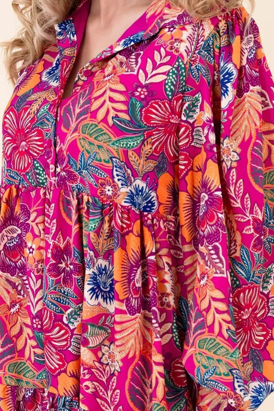 Close-up of the magenta tropical floral print, band collar and split V neckline of the Sway with the Blossoms mini dress