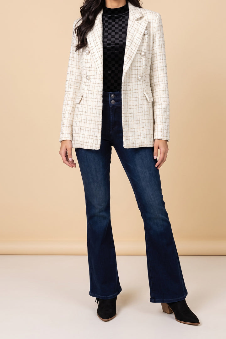 Front view of the Make It Happen cream tweed double-breasted blazer with pearl-look buttons, worn open over a black velvet mock neck top and dark flare jeans.