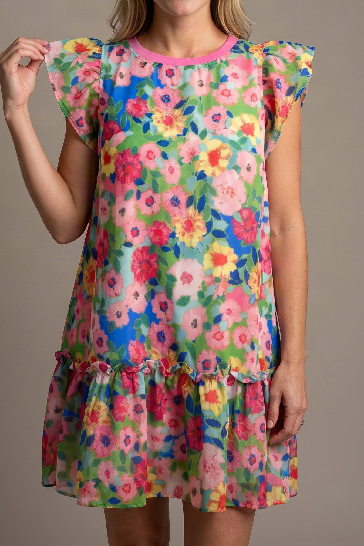 Model wearing the bright floral flutter-sleeve mini dress, shown from the chin down