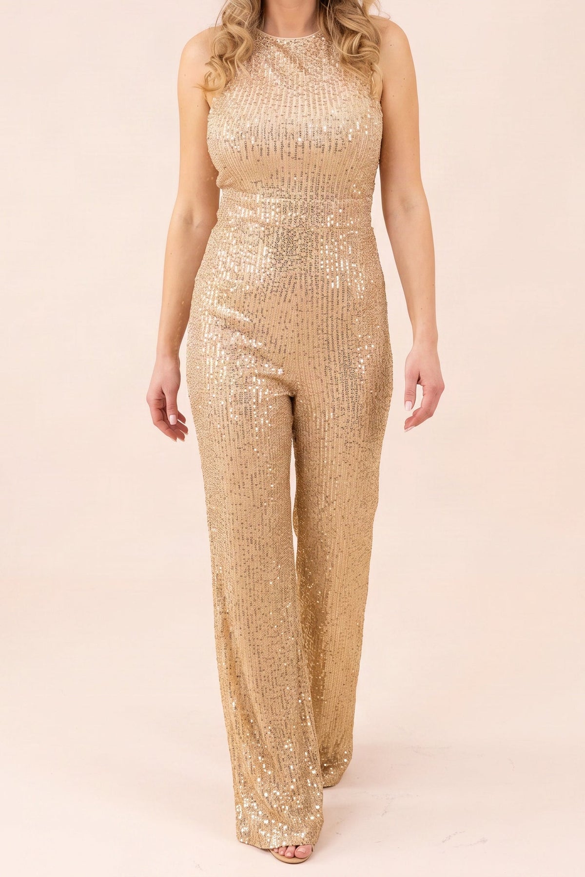 Model wearing the gold sequin sleeveless jumpsuit, shown from the chin down