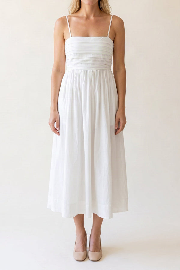 Model wearing the Love Actually white pleated midi dress, shown from the chin down