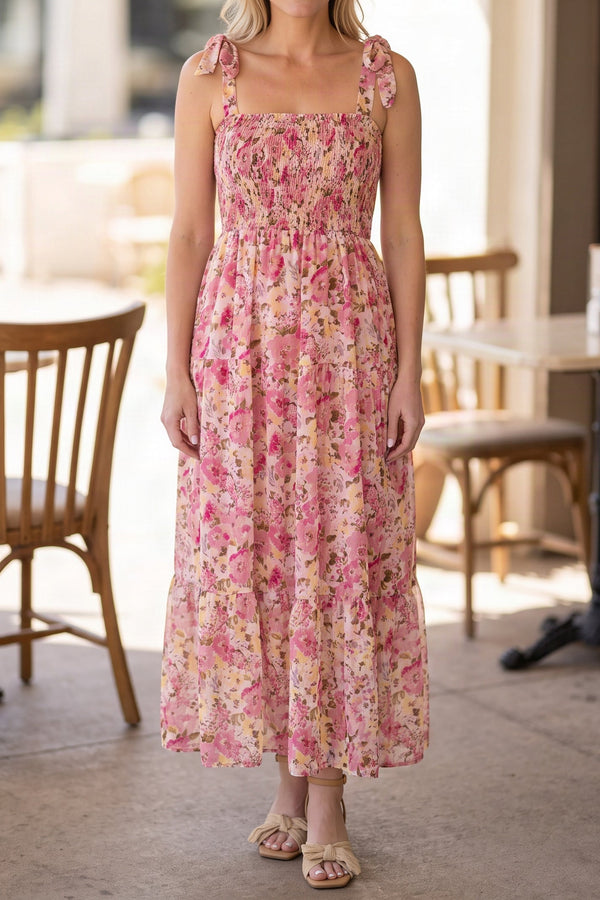 Model wearing the pink floral smocked maxi dress, shown from the chin down