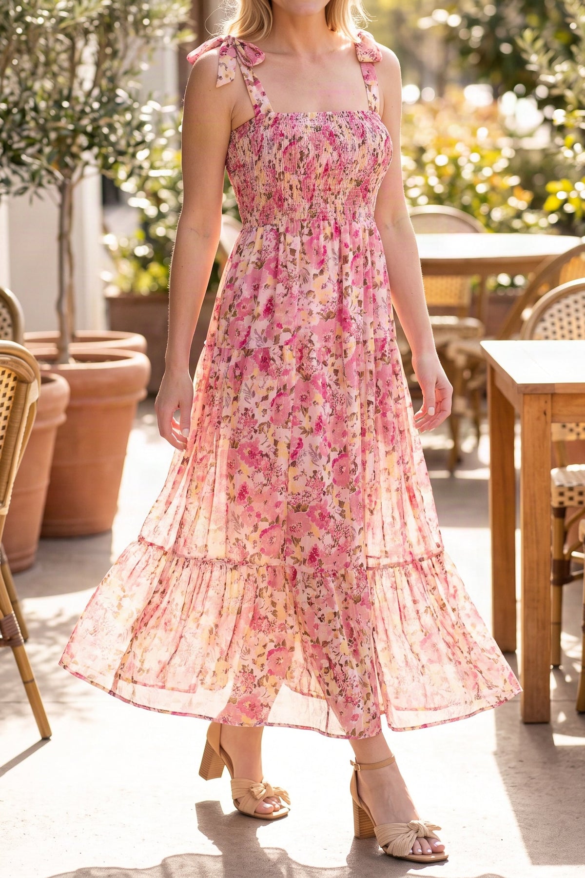 Model wearing the pink floral smocked maxi dress, shown from the chin down