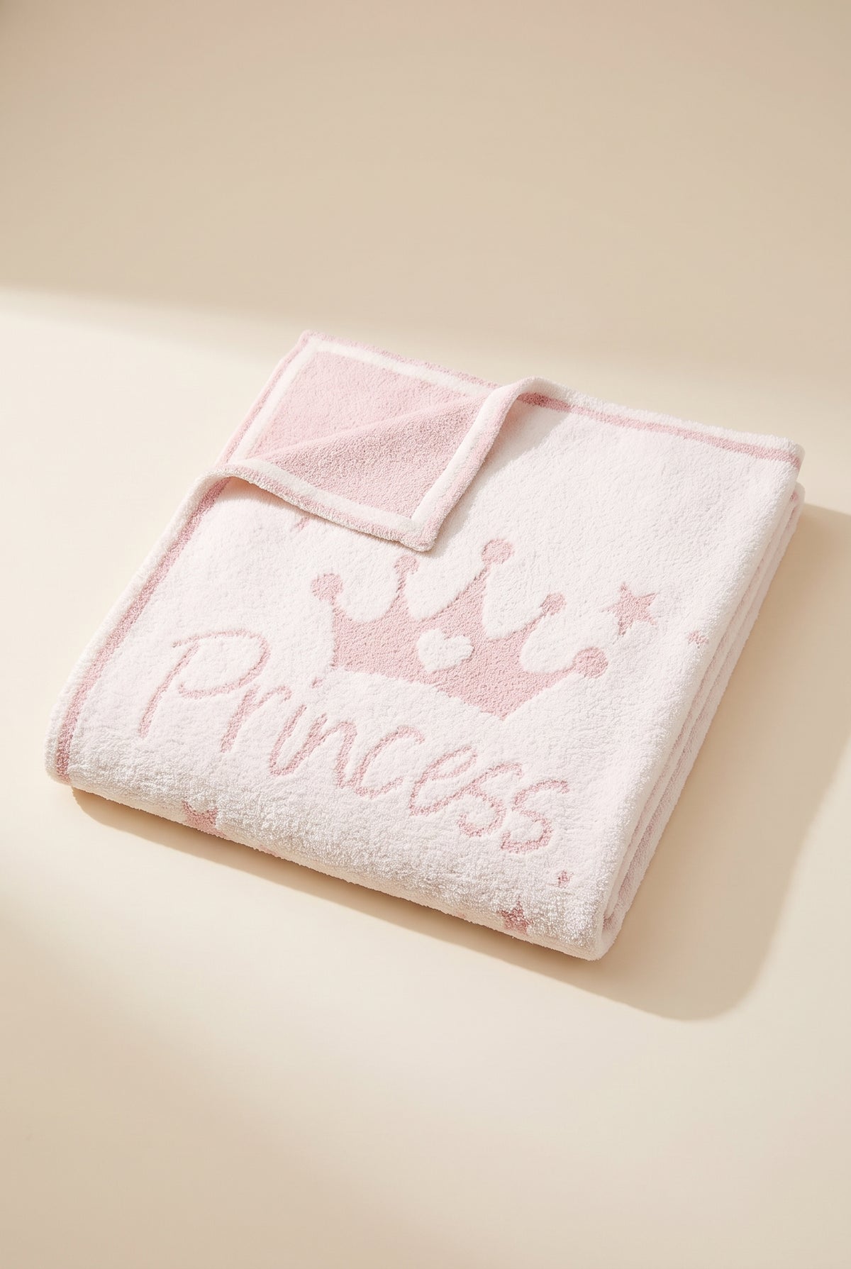 Molly Princess kids plush throw folded, ivory front with pink Princess script, crown and stars, corner turned to show the soft pink reverse
