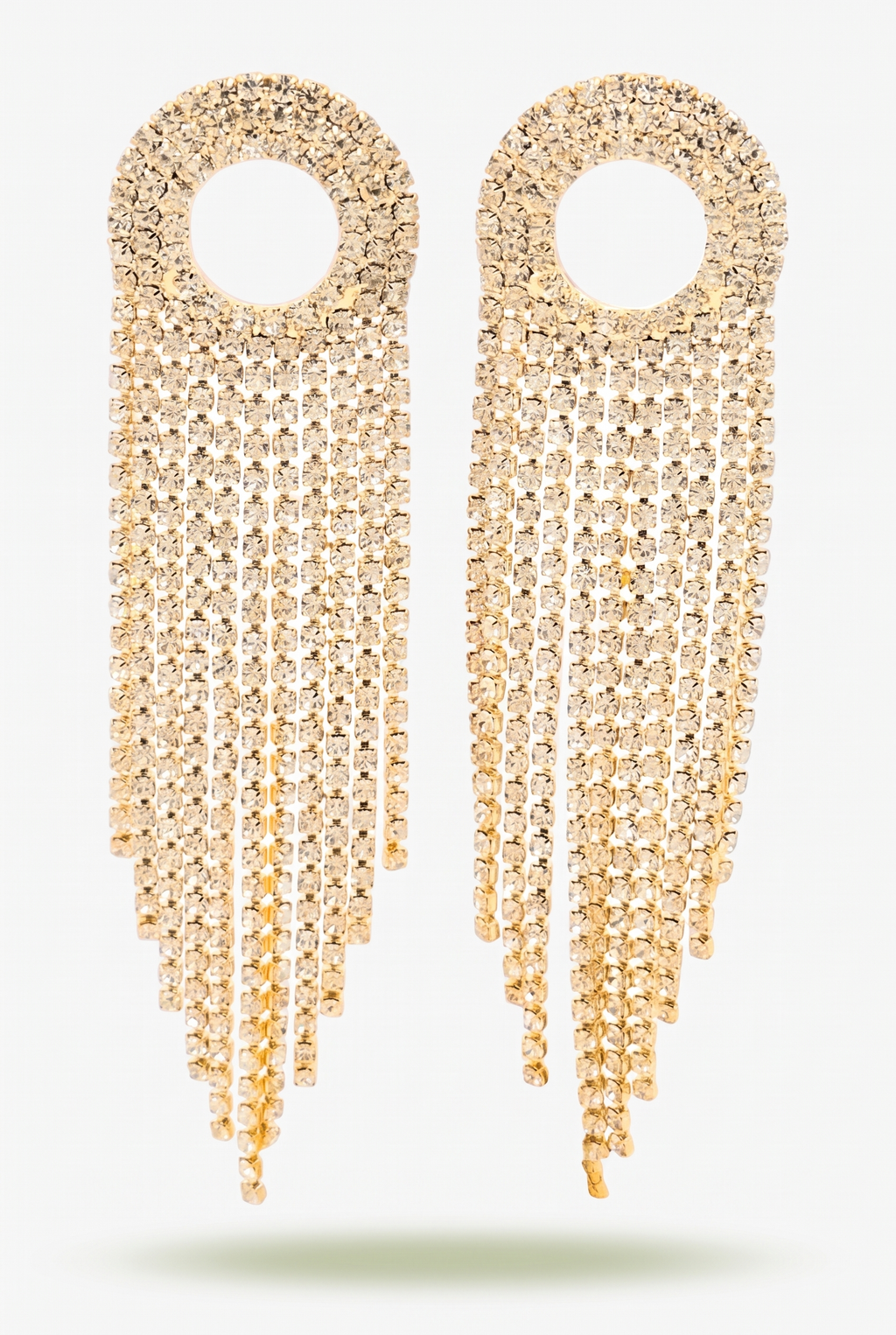 Nancy gold fringe earrings laid flat on a plain light studio background