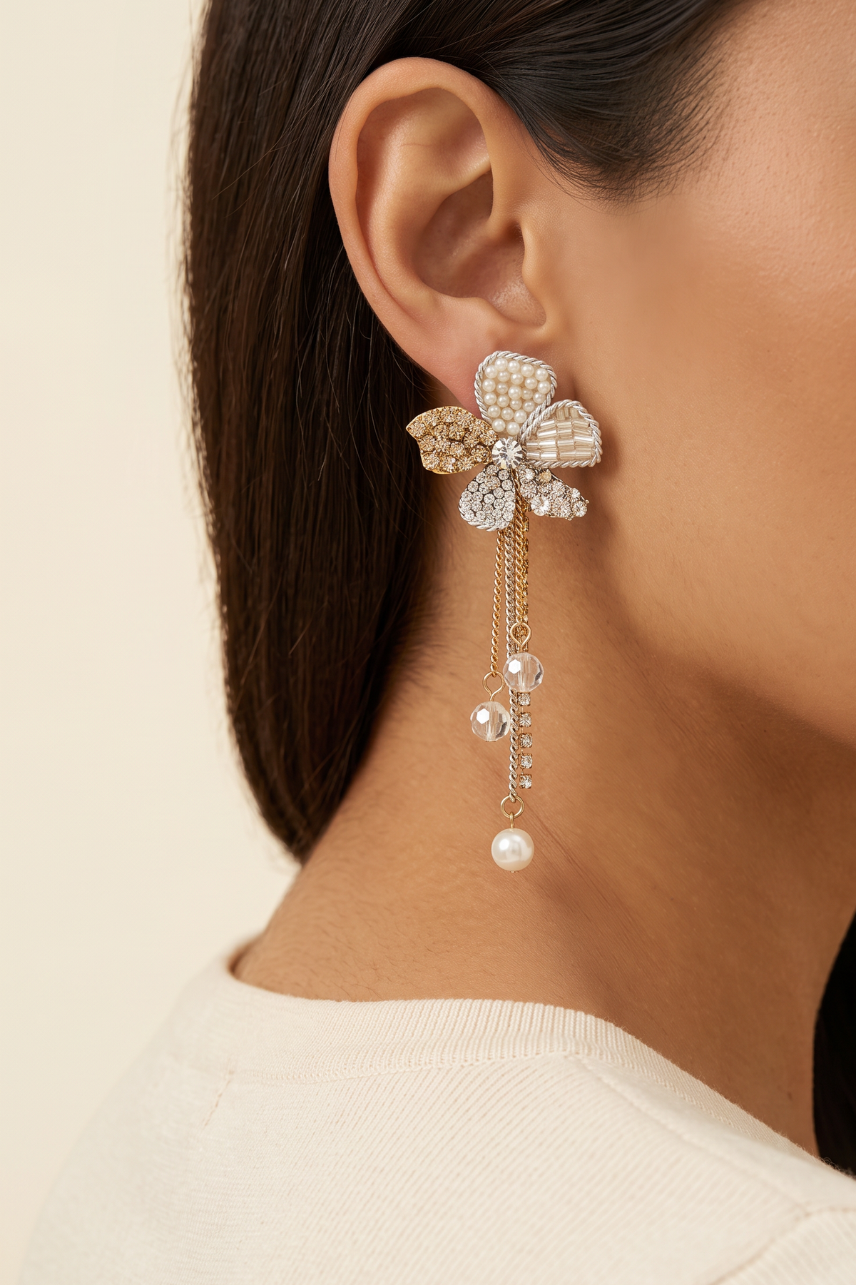 Orchid Flower Earrings worn on the ear, shown at true size: the flower sits on the lobe and the tassel ends just below the jawline
