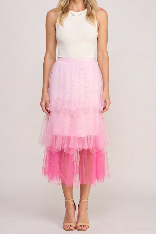 Pink layered tulle skirt worn with a white top, shown from the chin down