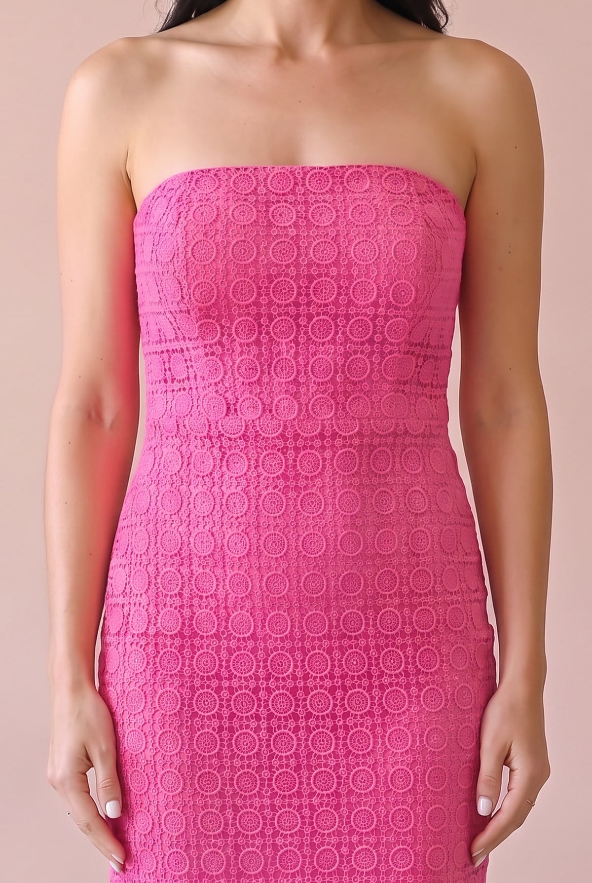 Close-up of the pink geometric crochet lace on the strapless bodice and fitted waist