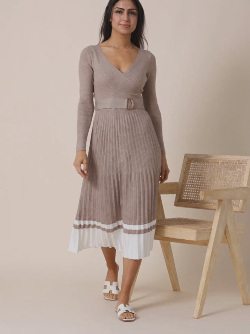 Shweta walks and turns gently in the beige pleated sweater dress as the skirt settles.