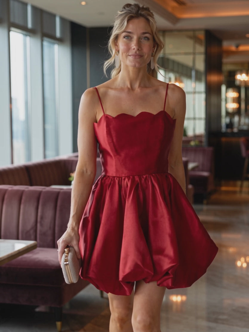 Elsa walking in the red scallop bubble mini dress as the rounded skirt moves through a gentle turn.