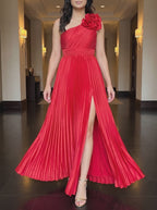 Red One More Night maxi dress worn in a warm hotel corridor, framed from the chin down, walking forward as the pleated skirt and slit move.