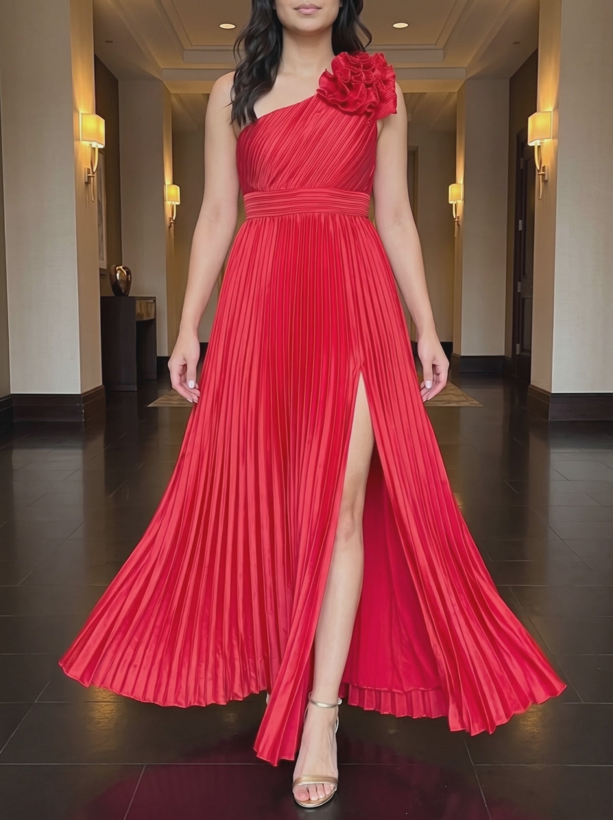 Red One More Night maxi dress worn in a warm hotel corridor, framed from the chin down, walking forward as the pleated skirt and slit move.
