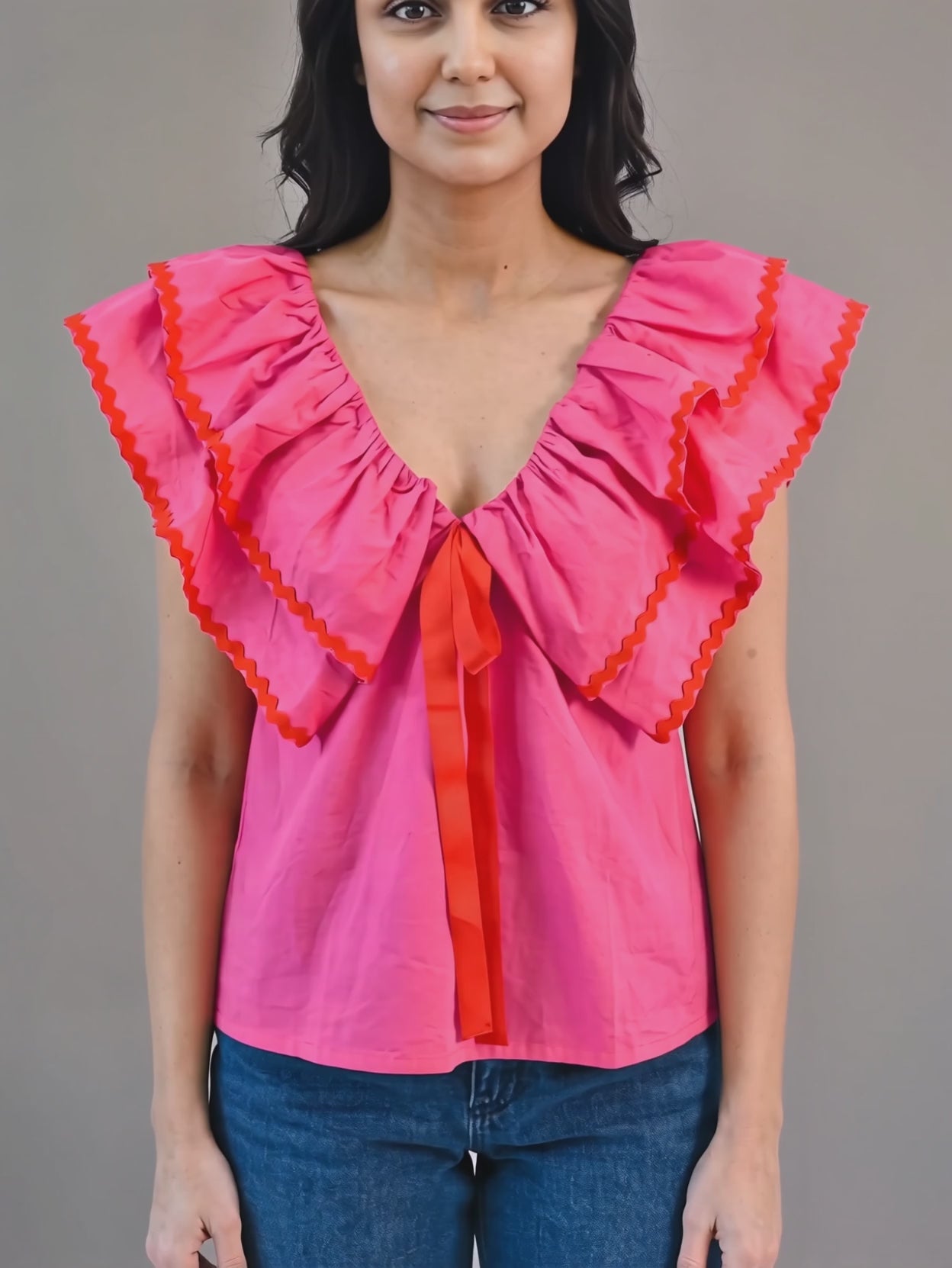 Pink ruffle babydoll top in motion showing the layered collar bounce and arm clearance.
