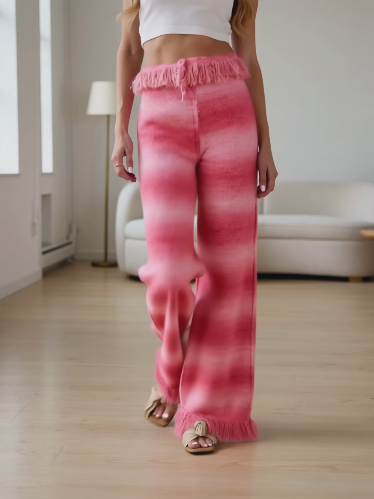 Elsa walking in Softly Spoken pink ombré pants to show the plush drape and moving fringe.