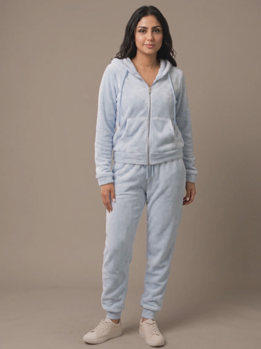 Light blue plush hoodie and pants set moving naturally in a neutral lounge.