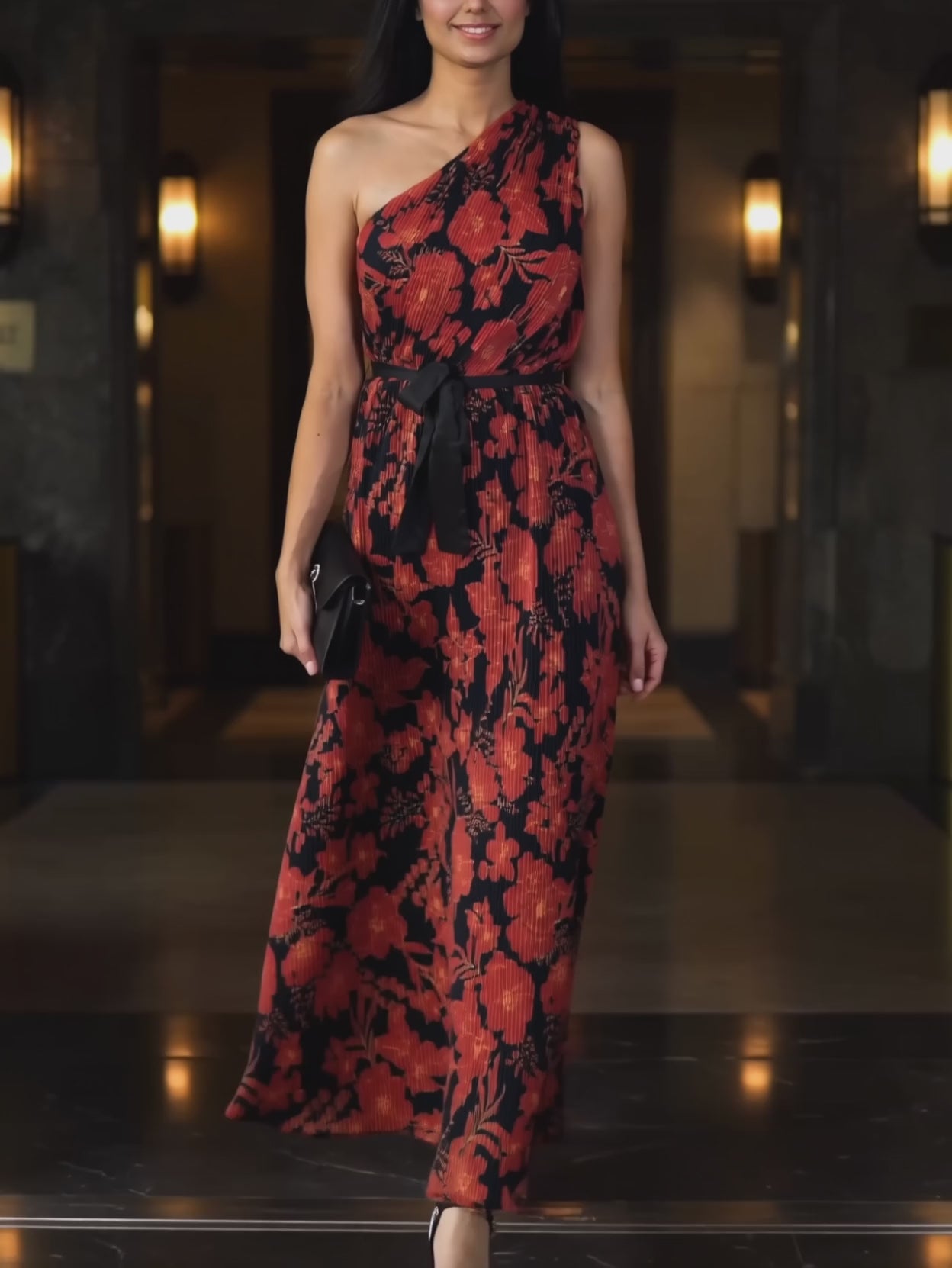 Floral pleated maxi dress moving through an evening entrance as the skirt swings and settles.