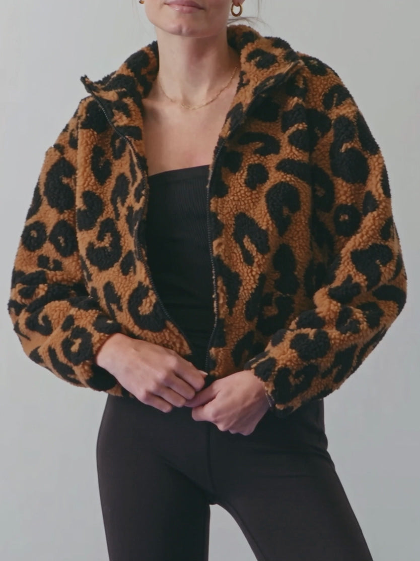 Going Wild leopard jacket in Small as Elsa zips it halfway and lets the sherpa drape settle.