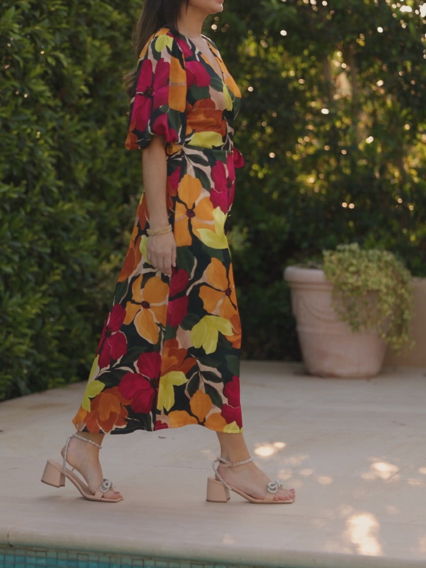 Floral wrap midi dress moving during a garden-brunch walk, showing the skirt overlap.