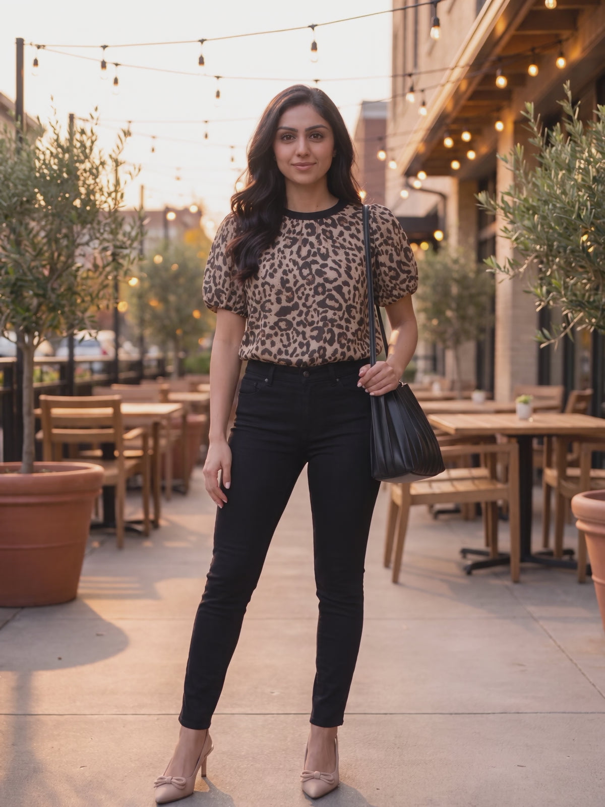 The taupe leopard puff sleeve top worn by Shweta at a downtown restaurant patio, stepping forward and turning to show the side and the fit.