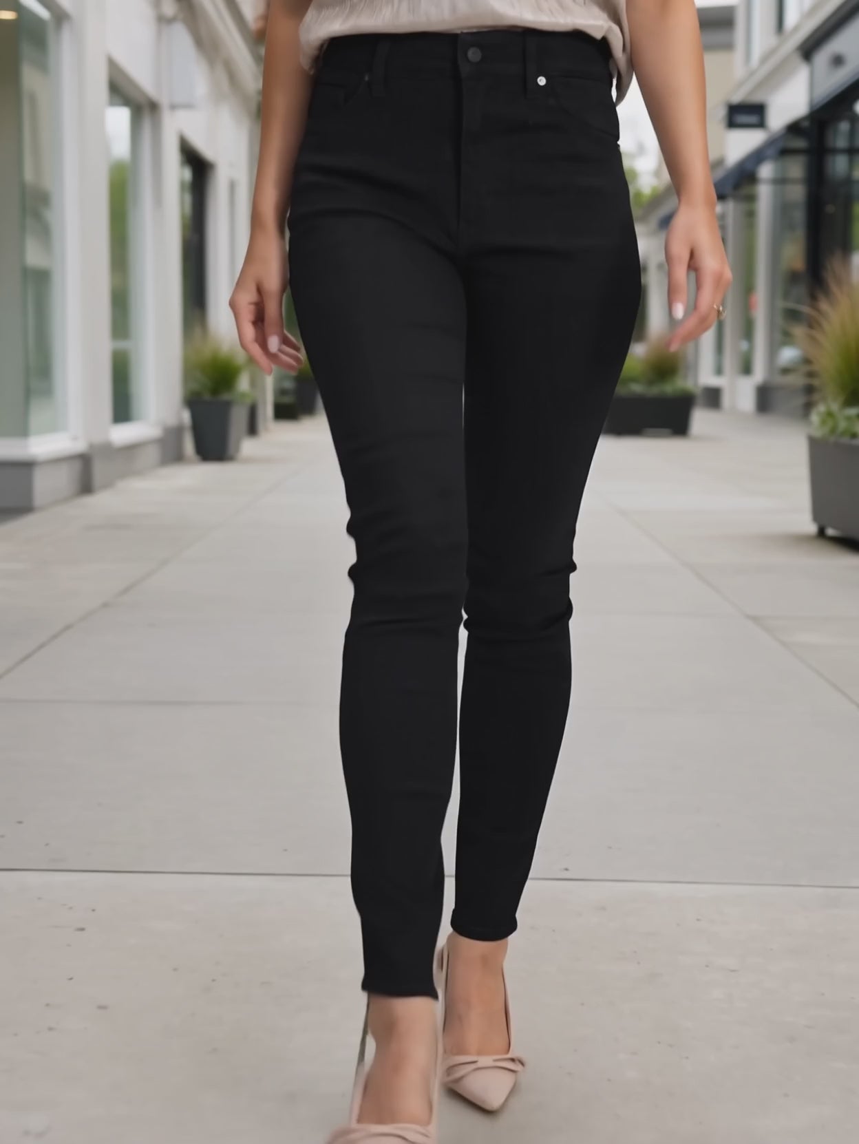 Elsa walking in Just Agree With Me black skinny jeans in an everyday sidewalk setting.