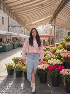 The Let's Just Stay pink daisy floral sweater worn by Shweta at a weekend flower market, stepping forward and turning to show the side and the fit.