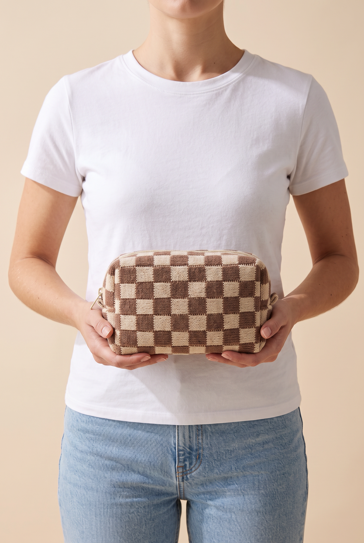Check Yourself Cosmetic Bag in Brown held at the waist at true size, about 8 inches wide, shown chin down with a white tee