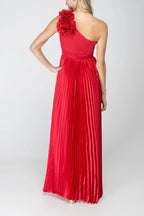 Back of the One More Night maxi dress in Red, showing the one-shoulder back, shoulder rosette and floor-length pleated skirt